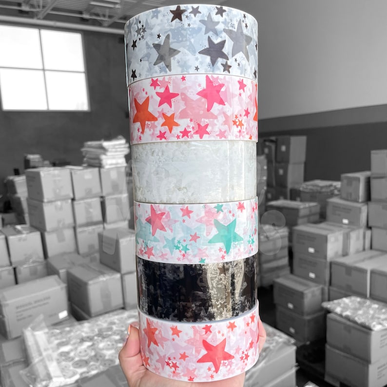 Puede incluir: Un rollo de cinta washi estampada compuesto por cinco rollos. La cinta presenta una variedad de dise&ntilde;os de estrellas en tonos grises, rosa, verde azulado y negro. La cinta es perfecta para agregar un toque de fantas&iacute;a a tus manualidades y proyectos.
