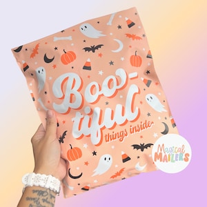 May include: A peach-colored poly mailer bag featuring a repeating Halloween pattern of white ghosts, orange pumpkins, black bats, candy corn, and crescent moons. The text "Boo-tiful things inside" is printed in large white script across the center.