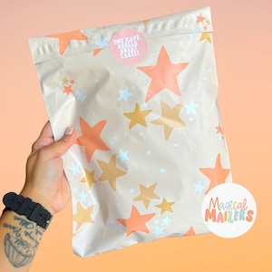 May include: A beige poly mailer with a star pattern in shades of orange and gold. The mailer has a pink sticker that says "You have really great taste!" and a white sticker that says "Magical Mailers".