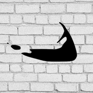 May include: Black silhouette of the island of Martha's Vineyard against a white brick wall background.