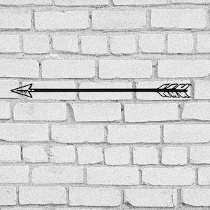 May include: A black arrow with a feathered tail is drawn on a white brick wall.