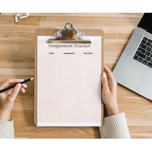 May include: A white clipboard with a pink background and the text "Assignment Tracker" at the top. The clipboard has three columns labeled "Class", "Assignment", and "Due Date".