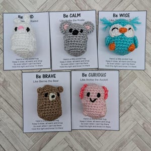 May include: Five crocheted animal plushies with inspirational messages. Each plush is a different colour and has a different animal design. The messages are "Be Brave", "Be Calm", "Be Wise", "Be Curious", and "Be Kind".