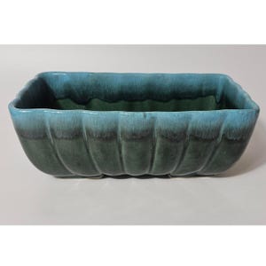 May include: A rectangular ceramic planter with a scalloped edge design. The exterior features a gradient glaze transitioning from a deep forest green at the base to a bright turquoise blue along the top rim, creating a smooth, glossy finish.