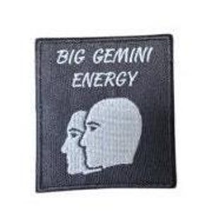 May include: Black embroidered patch with white text that reads "BIG GEMINI ENERGY" and a white outline of two facing profile heads.