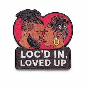 May include: Embroidered patch featuring a couple in profile, their faces close together within a red heart. The patch includes the text "LOC'D IN, LOVED UP" in white lettering on a black background.
