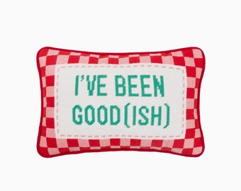 May include: Rectangular decorative pillow with a red and white checkered border. The center features the text "I'VE BEEN GOOD(ISH)" in green letters on a white background. The pillow is a fun, playful home decor item.