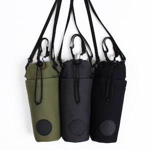 May include: Three water bottle carriers with adjustable straps. The carriers are made of black and green fabric with a drawstring closure. The carriers have a logo that says "Ridge Tool Co."