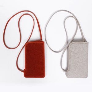 May include: Two small crossbody bags with adjustable straps. The bag on the left is red and the bag on the right is light gray.