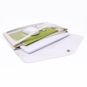 May include: A white plastic folder with a clear front panel. The folder is open and contains a green notebook, a white computer mouse, and a white laptop. The notebook has the word "SCHOOL" written on the cover.