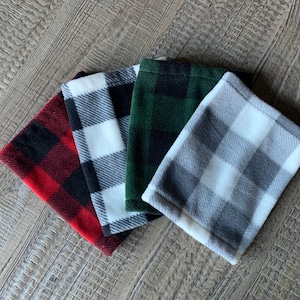 May include: Four fleece neck warmers in different plaid patterns: red and black, black and white, green and black, and gray and white.