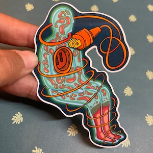 May include: A sticker featuring a stylized illustration of a person with an electrical cord wrapped around them. The cord is plugged into a socket in the person's chest. The person is outlined in green and has red and orange patterns inside. The cord is orange and black.