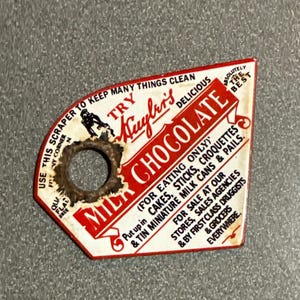 May include: Vintage Huyler's Milk Chocolate scraper. The red and white scraper has a circular hole and text that reads "Try Huyler's Delicious Chocolate" and "For Eating Only". The scraper is used to keep things clean.