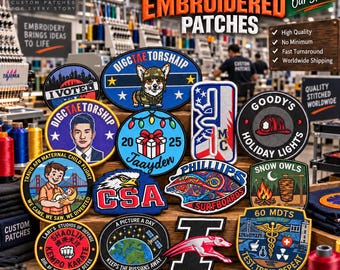 May include: A collection of various custom embroidered patches featuring diverse designs including a corgi, a person, a gift box, a bald eagle, a surfboard, a greyhound, and medical symbols, displayed on a wooden surface in a workshop.