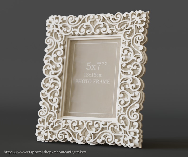Pu&ograve; includere: Una cornice bianca e ornata con un design decorativo a spirale. La cornice &egrave; progettata per contenere una foto di 13x18 cm (5x7 pollici). La cornice &egrave; realizzata in un materiale di colore chiaro e ha un aspetto dettagliato e stratificato.