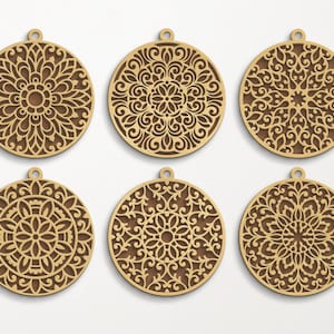 May include: Six wooden ornaments with intricate laser-cut designs. Each ornament features a circular mandala pattern with a brown wood finish.