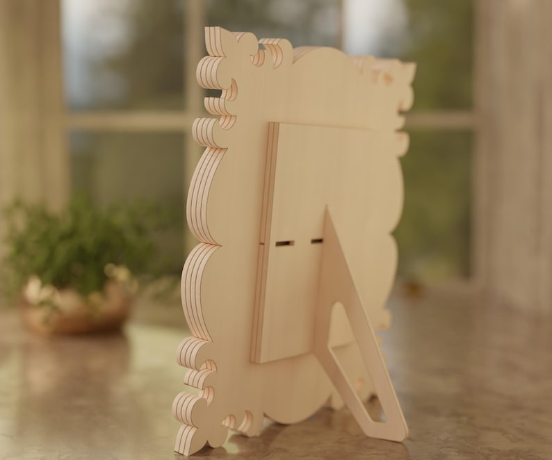 May include: A light-colored wooden picture frame with a decorative, layered edge. The frame has a built-in easel back for tabletop display. The frame is designed with a scalloped edge and is suitable for photos or artwork.