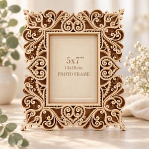 May include: A rectangular wooden photo frame featuring intricate laser-cut scrollwork and heart-shaped patterns. The center insert displays the text 5x7 inches and 13x18 cm PHOTO FRAME. The frame has a layered, light brown wood finish.