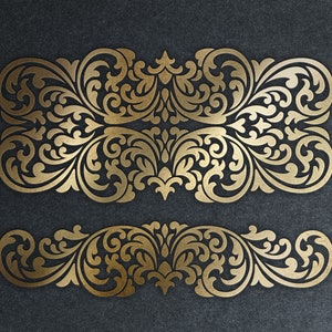 May include: Two ornate gold-coloured decorative borders with intricate floral designs. The borders are symmetrical and feature a repeating pattern of leaves and swirls.