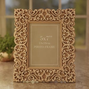 Pu&ograve; includere: Una cornice per foto in legno tagliata al laser con un intricato design a volute. La cornice &egrave; progettata per una foto di 13x18cm e include il testo "PHOTO FRAME". L'immagine include anche il testo "VECTOR FRAME DESIGN" e informazioni sul tipo di file.
