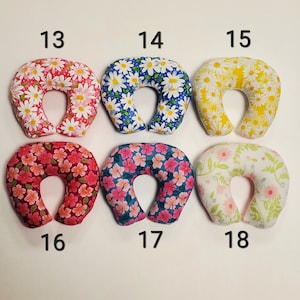 K&ouml;nnte beinhalten: Sechs verschiedene Nackenst&uuml;tzkissen mit Blumenmustern. Die Kissen sind in den folgenden Farben: rosa, blau, gelb, rot, t&uuml;rkis und wei&szlig;. Die Kissen sind von 13 bis 18 nummeriert.