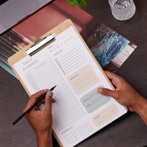 May include: A white daily planner with a wooden clipboard, featuring sections for time, plans and schedule, to do list, important, water, read, shopping list, and notes. The planner has a light brown background and a light gray grid.