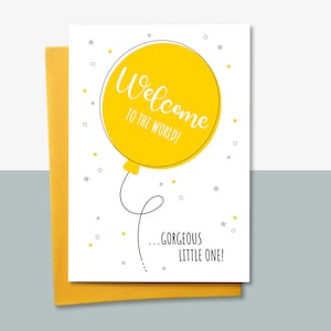 May include: A white card with a yellow balloon illustration that says "Welcome to the world!" and "...gorgeous little one!" with grey stars and dots in the background.