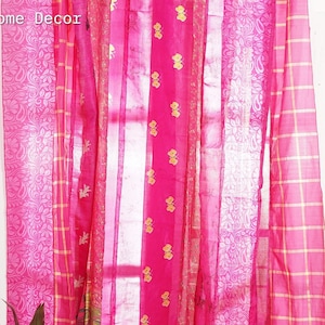 Peut inclure: Rideaux en patchwork rose et or avec un motif à carreaux. Les rideaux sont accrochés à un mur blanc avec une petite plante dans un pot noir.