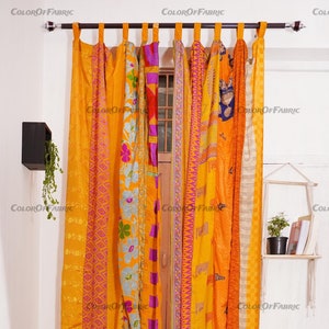 Könnte beinhalten: Ein Paar gelbe, orangefarbene und rosafarbene Patchwork-Vorhänge mit einem Blumenmuster. Die Vorhänge sind an einer schwarzen Gardinenstange aufgehängt.