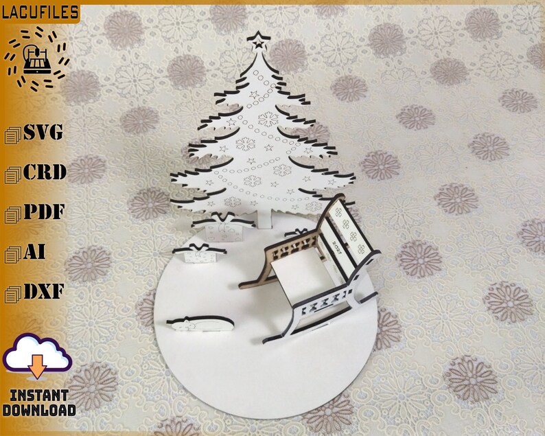 May include: A white laser-cut Christmas scene featuring a tree, presents, and a rocking chair on a circular base. The tree has snowflake and star cutouts. The image includes the text "LACUFILES" and "INSTANT DOWNLOAD".