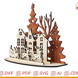May include: Laser cut wooden Christmas scene with three houses, a Christmas tree, and a reindeer-drawn sleigh with Santa Claus. The houses are white with brown trim and windows. The Christmas tree is brown with white stars. The sleigh is brown with white trim. The reindeer are brown with white antlers.