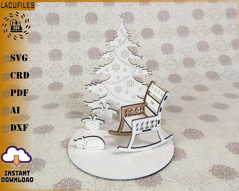 May include: A laser-cut Christmas scene featuring a tree, presents, a rocking chair, and a sleeping cat. The chair has a brown seat and white frame. The scene is on a white circular base. The text "INSTANT DOWNLOAD" is visible.