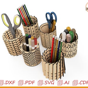 May include: Five wooden pencil holders with different designs. The holders are made of laser-cut wood and feature various patterns, including letters, stripes, and geometric shapes. The holders are filled with pencils, pens, and scissors.