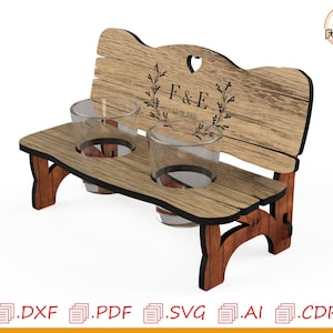 Könnte beinhalten: Getränkehalter in Form einer Holzbank mit zwei Glashaltern. Die Bank hat einen herzförmigen Ausschnitt und die eingravierten Initialen "F & E" mit einem Datum. Das Design besteht aus braunem Holz mit dunkelbraunen Akzenten.