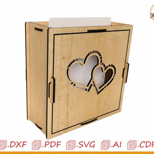 May include: A wooden box with a cutout of two hearts. The box is made of light wood and has a natural finish. The hearts are cut out of the front of the box and are visible through the opening.