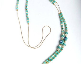 May include: A turquoise and gold beaded eyeglass chain with two blue evil eye charms. The chain is made of small beads and has a gold metal clasp.