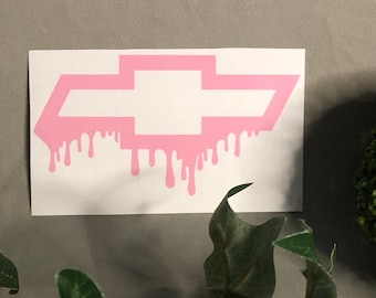 May include: Pink vinyl decal of a Chevrolet bowtie with dripping paint effect.