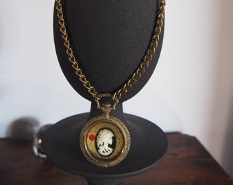 Inspiración gótica para este reloj de collar con bolsillo y cameo esqueleto