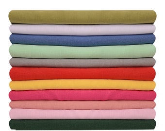 May include: A stack of 10 folded fabric t-shirts in various colours, including green, purple, blue, pink, red, yellow, and grey.