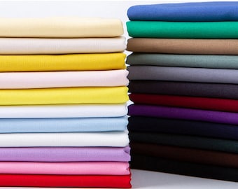 May include: A stack of fabric swatches in various colors, including beige, yellow, white, light blue, lavender, pink, and red.