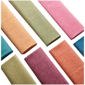 May include: Eight fabric swatches in various colors, including teal, orange, green, pink, and red. The swatches are arranged in a fan shape on a white background.