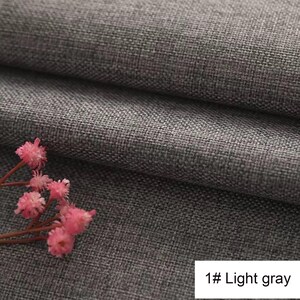 May include: A light grey fabric with a visible woven texture and a folded appearance. A small cluster of delicate pink flowers with thin stems is positioned in the lower left corner. The text 1# Light grey is printed in the bottom right corner.