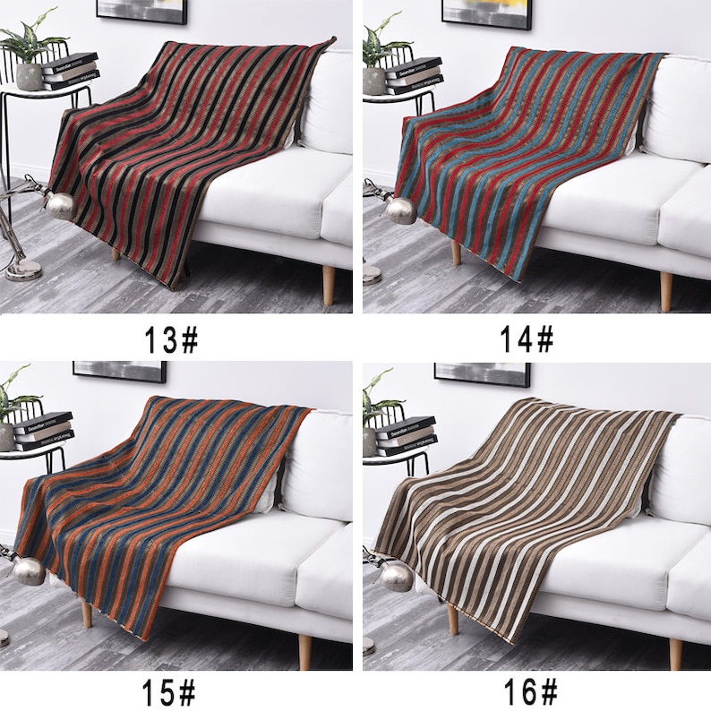 May include: Four striped throw blankets displayed on white sofas. The blankets are in different color combinations: red and black, blue and red, orange and blue, and brown and white.