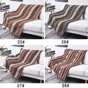 May include: Four different patterned throw blankets are displayed on white sofas. The blankets feature a variety of colors, including brown, red, black, and white. The blankets are made of a soft, comfortable fabric and are perfect for adding a touch of style to any room.