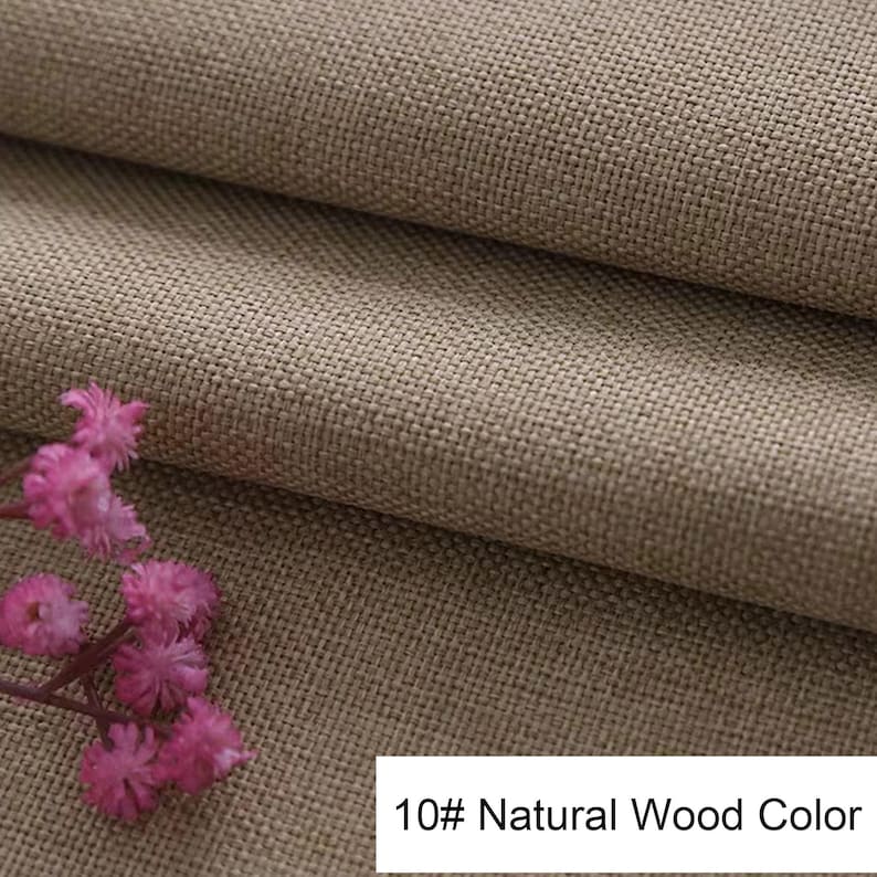 May include: A piece of tan-coloured fabric with a visible woven texture, folded to create layers. A small cluster of pink flowers is positioned on the lower left side. A white rectangular label displays the text 10# Natural Wood Color.