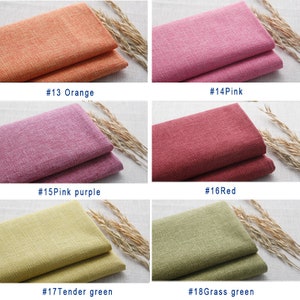 May include: Six fabric swatches in different colors: orange, pink, pink purple, red, tender green, and grass green. The fabric has a textured, linen-like appearance.