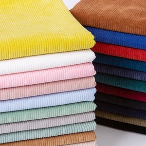 May include: A stack of corduroy fabric in various colors, including yellow, white, pink, blue, green, brown, red, and black.