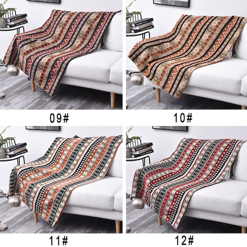 May include: Four different patterned throw blankets in various shades of brown, red, black, and white are draped over white sofas. The blankets have a geometric pattern with stripes and small shapes.