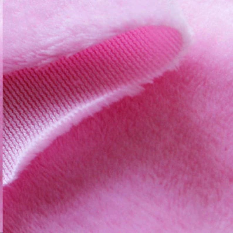 May include: Close-up of a pink fabric with a ribbed texture. The fabric is soft and fuzzy, with a subtle sheen.