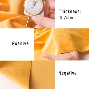 May include: Close-up of a yellow fabric with a measurement tool showing a thickness of 0.7mm. The fabric has a smooth, velvety texture on one side and a textured, woven texture on the other side. The text "Positive" and "Negative" are visible, indicating the two sides of the fabric.